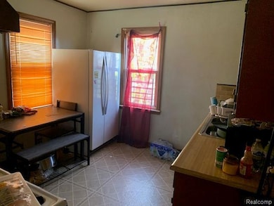 Kitchen featuring freestanding refrigerator, light countertops, and light flooring