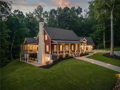 Back of property at dusk with a yard, covered porch, and a chimney