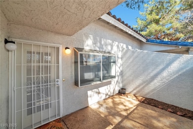 Property entrance with a tile roof and stucco sidi