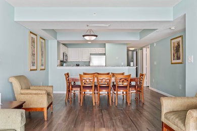 Dining space with baseboards and dark wood-style f