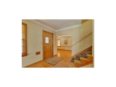 Original wooden door and hardwood stairs.