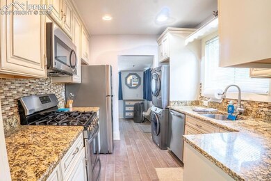 Kitchen featuring stacked washing maching and drye