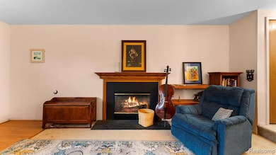 Sitting room with a fireplace with flush hearth and wood finished floors