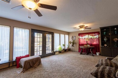 Carpeted living room featuring french doors and ce