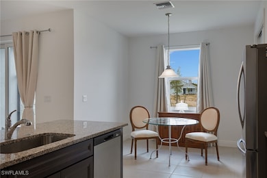 Kitchen with light stone counters, a sink, and sta