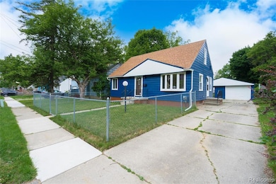 Bungalow featuring a detached garage, an outbuilding, a shingled roof, and a fenced front yard