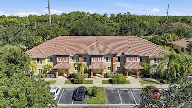 View of front of home featuring a tile roof, stucco siding, and uncovered parking
