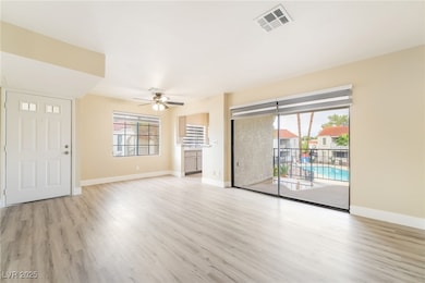 Unfurnished living room with light wood finished floors and a ceiling fan