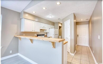 Kitchen featuring a breakfast bar area, white refr