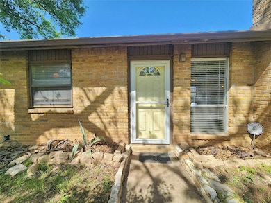 Entrance to property featuring brick siding