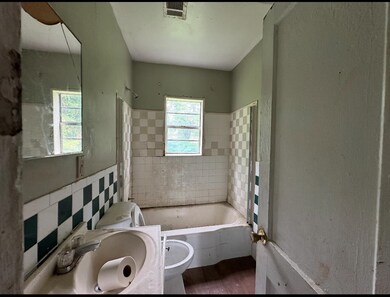 Full bath featuring toilet, wood finished floors, tile walls, vanity, and wainscoting