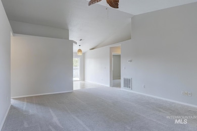 Carpeted empty room with vaulted ceiling and ceiling fan