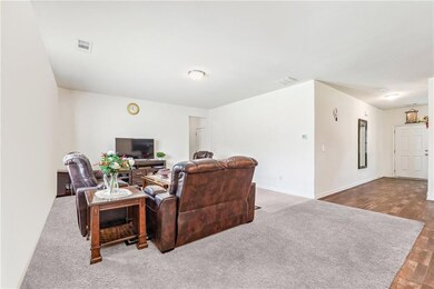 Living area with baseboards and dark carpet