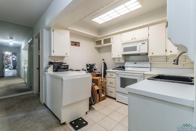 Kitchen featuring white cabinets, light tile patte