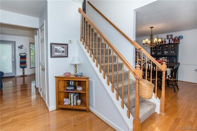 Stairway with an inviting chandelier, a textured c
