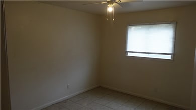 Empty room with ceiling fan and light tile pattern