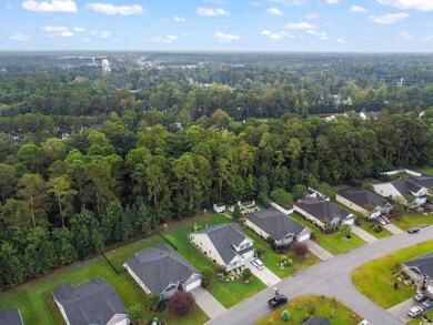 Aerial overview of property's location featuring nearby suburban area and a forest
