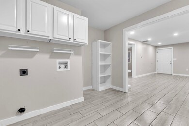 Laundry room with hookup for an electric dryer, wood tiled floors, washer hookup, recessed lighting, and cabinet space