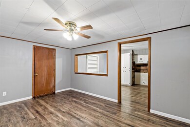 Spare room featuring dark wood-style floors, crown