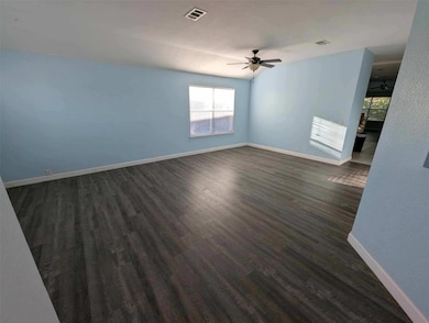 Unfurnished room featuring dark wood finished floors and ceiling fan