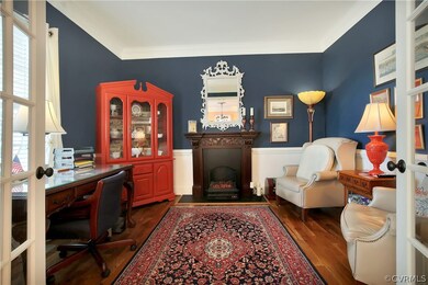 Living room/study has a faux fireplace that does c