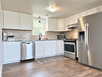 Kitchen with hardwood / wood-style floors, white c