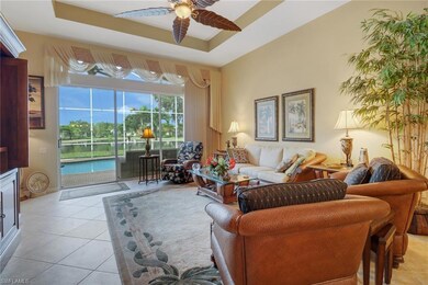 Tiled living room featuring a tray ceiling and cei