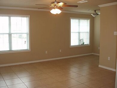 Empty room featuring crown molding, light tile pat