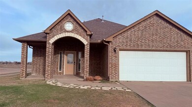 View of front facade featuring driveway, a front y