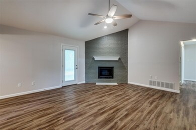 Unfurnished living room with vaulted ceiling, ceiling fan, dark hardwood / wood-style floors, and a fireplace