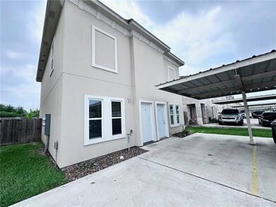 Rear view of property featuring stucco siding and fence