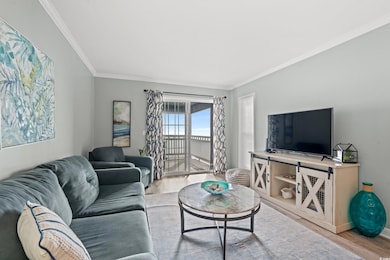 Living room with crown molding and light hardwood 