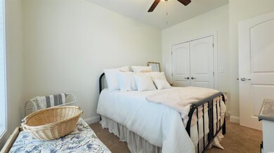 Carpeted bedroom featuring a closet and ceiling fan