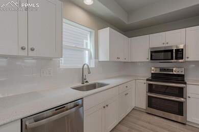 Kitchen with light wood-style flooring, white cabi