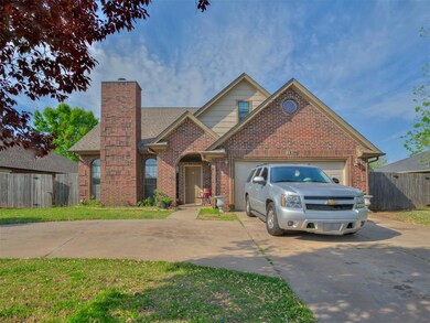 View of front of home featuring brick siding, concrete driveway, a chimney, and a garage