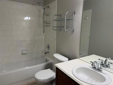 Full bathroom featuring tiled shower / bath combo, toilet, and vanity