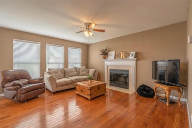 Living room with wood burning fireplace and hardwo