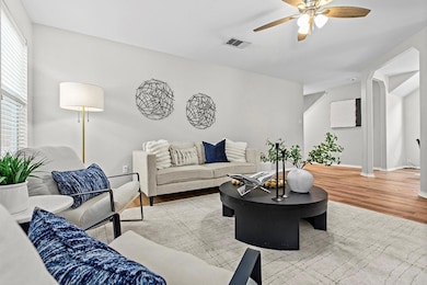 Living room featuring baseboards, a ceiling fan, 