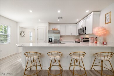 Kitchen featuring a sink, a breakfast bar, white c