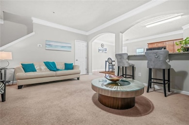 Living room featuring light carpet, arched walkway
