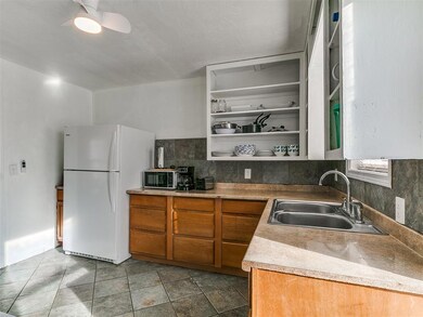 Kitchen with a sink, backsplash, brown cabinets, f