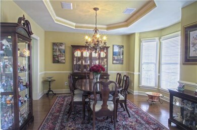 Dining room is bathed in sunlight by day through bay windows.  At night adjust the chandelier for just the right mood with adjustable light sliders.