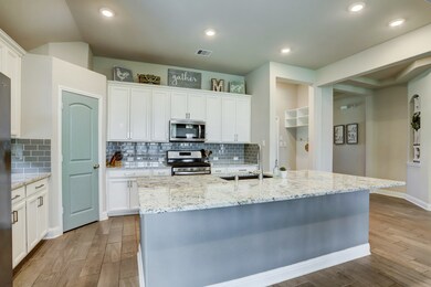 KITCHEN  This light and bright kitchen will thrill the inner chef with stainless steel appliances and an enormous island with slab granite countertop and ample seating.  A smart mudroom nook is positioned just inside the garage door and provides space for shoes, backpacks and more.