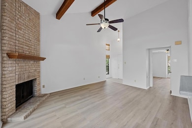 Unfurnished living room with a ceiling fan, a bri