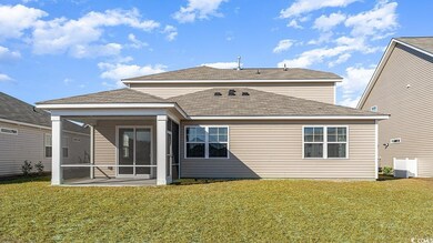 Back of house featuring a sunroom and a lawn