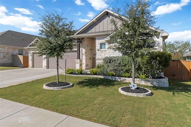 View of front of house with board and batten siding, stone siding, driveway, and an attached garage