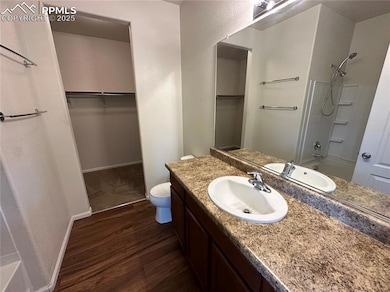 Full bath with vanity, a spacious closet, toilet, 