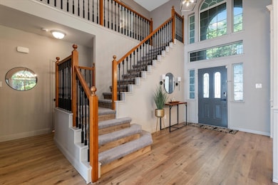 Foyer entrance with a towering ceiling and LVP / wood-style flooring