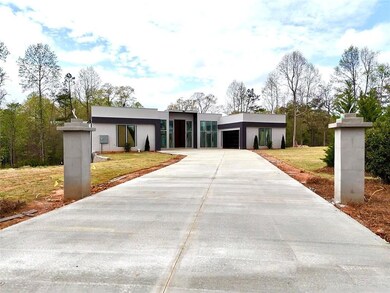Modern home with a garage, driveway, a front lawn