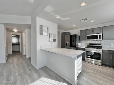 Kitchen featuring tasteful backsplash, light wood-
